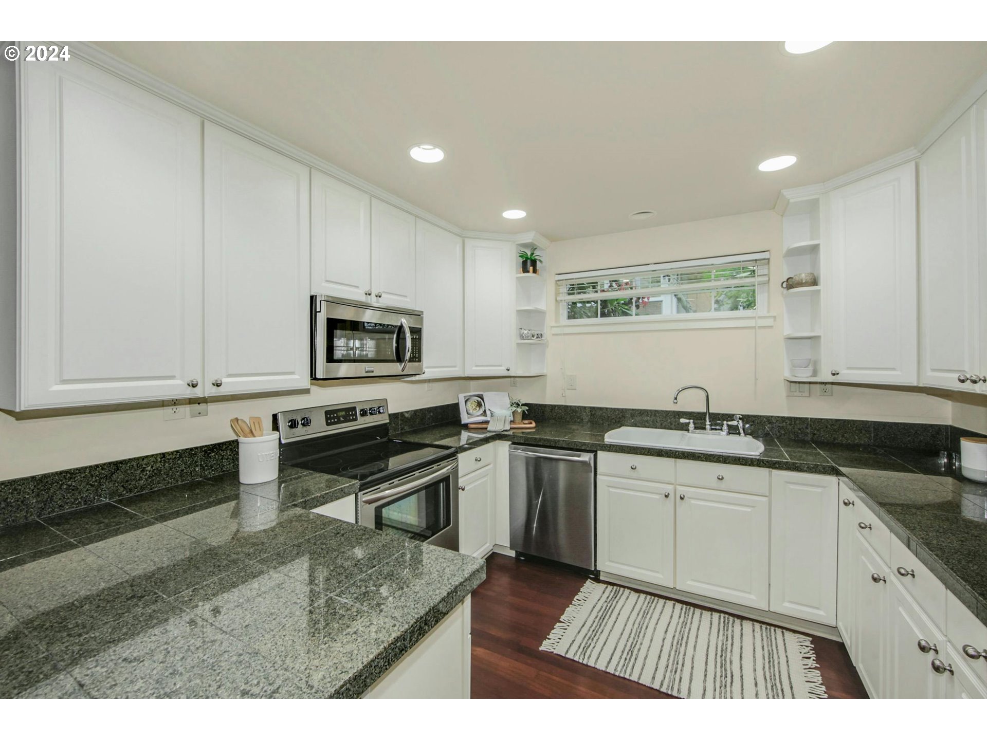 2324 Northwest Miller Road Portland, OR 97229 - Photo 13 of 29 a kitchen with stainless steel appliances granite countertop a stove a sink and a microwave