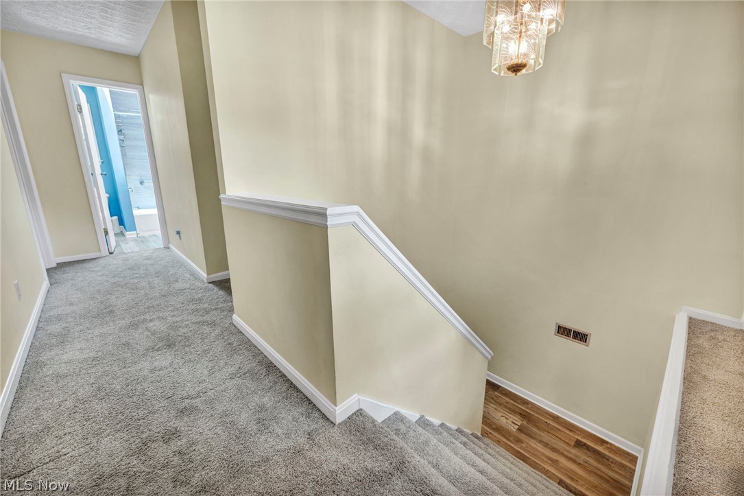 3005 Kendall Road Akron, OH 44321 - Photo 21 of 46 Stairway featuring carpet floors and a notable chandelier
