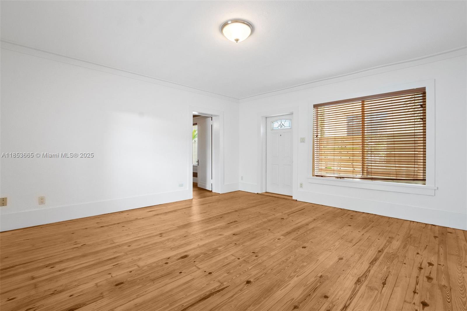 1721 Southwest 21st Terrace, Unit 1719 Miami, FL 33145 - Photo 11 of 25 a view of an empty room with wooden floor and a window