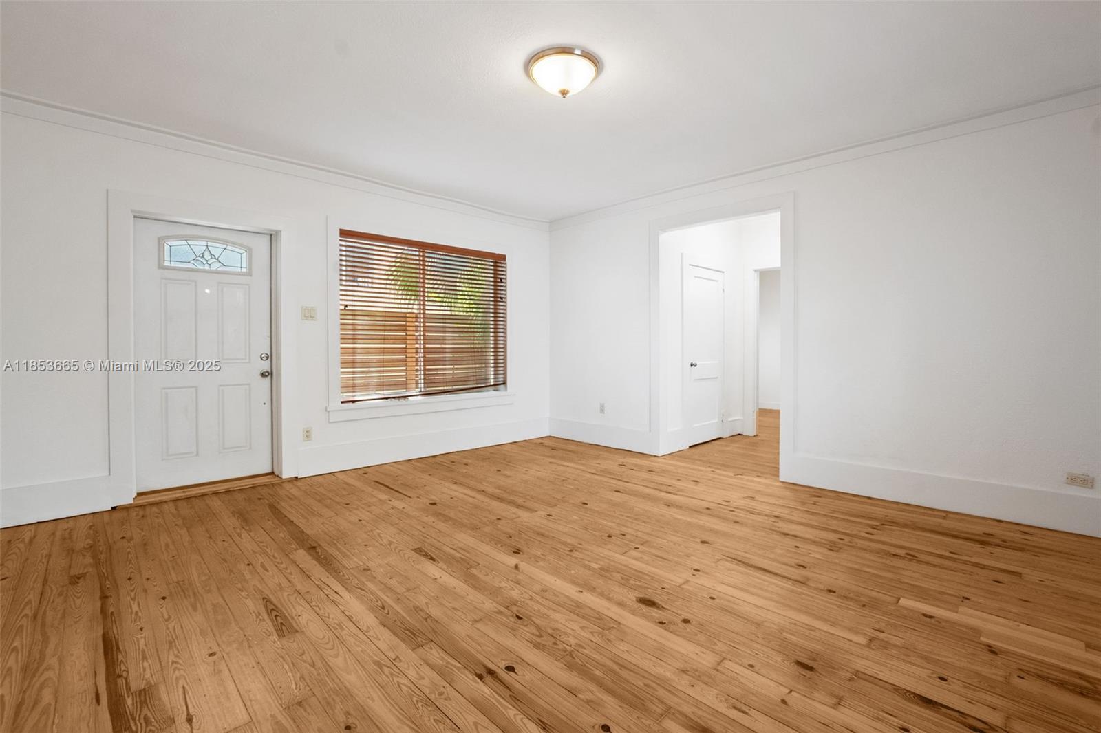 1721 Southwest 21st Terrace, Unit 1719 Miami, FL 33145 - Photo 12 of 25 a view of an empty room with wooden floor and a window