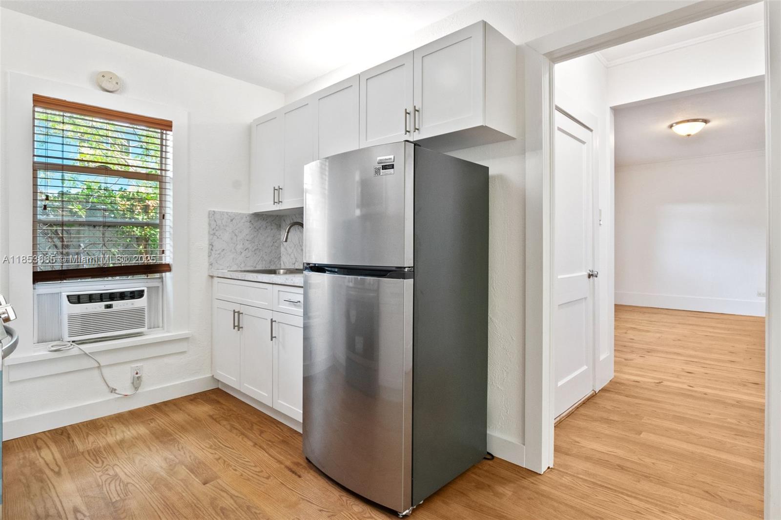 1721 Southwest 21st Terrace, Unit 1719 Miami, FL 33145 - Photo 2 of 25 a kitchen with white cabinets and refrigerator