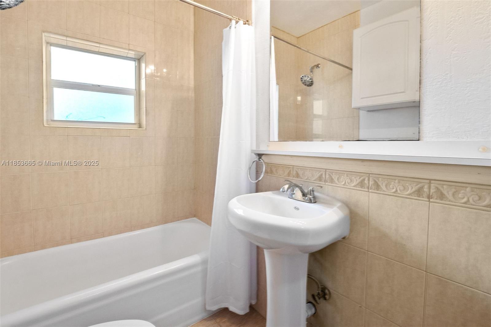 1721 Southwest 21st Terrace, Unit 1719 Miami, FL 33145 - Photo 22 of 25 a bathroom with a sink a mirror and a bathtub