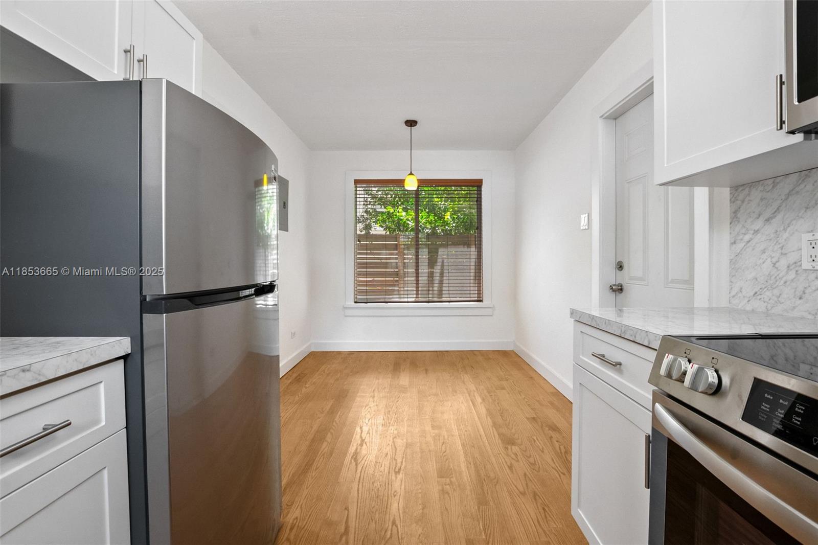 1721 Southwest 21st Terrace, Unit 1719 Miami, FL 33145 - Photo 5 of 25 a kitchen with a stove a refrigerator and a window