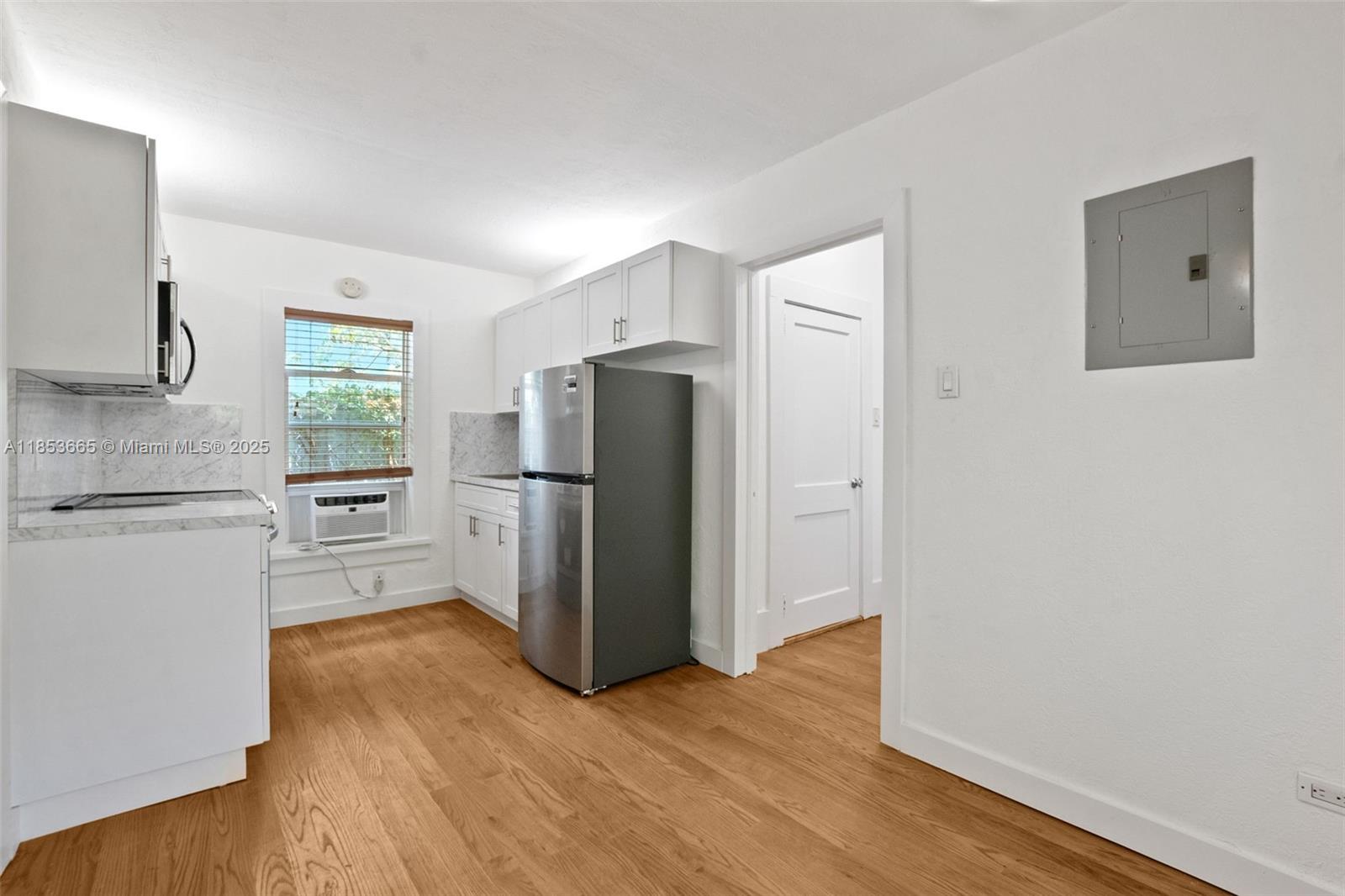 1721 Southwest 21st Terrace, Unit 1719 Miami, FL 33145 - Photo 7 of 25 a kitchen with stainless steel appliances a refrigerator and a wooden floor