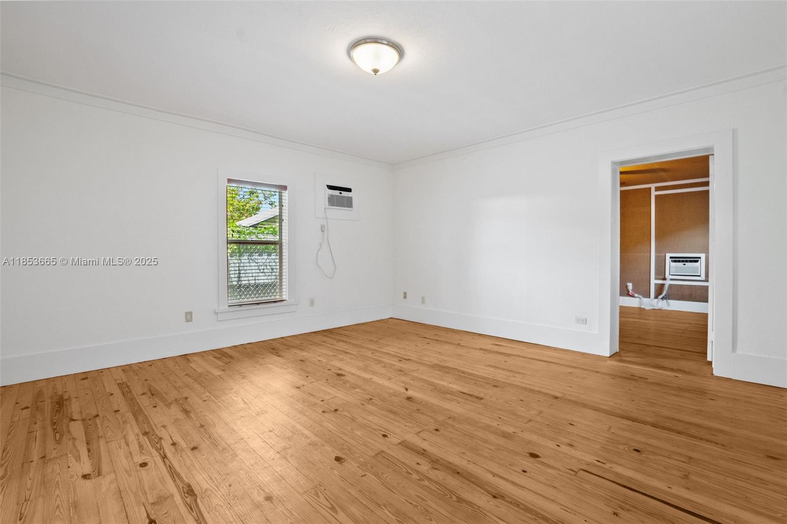 1721 Southwest 21st Terrace, Unit 1719 Miami, FL 33145 - Photo 10 of 25 a view of an empty room with window and wooden floor