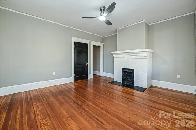 a view of empty room with wooden floor and fireplace