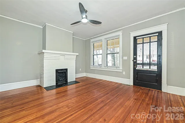 a view of empty room with wooden floor and fireplace