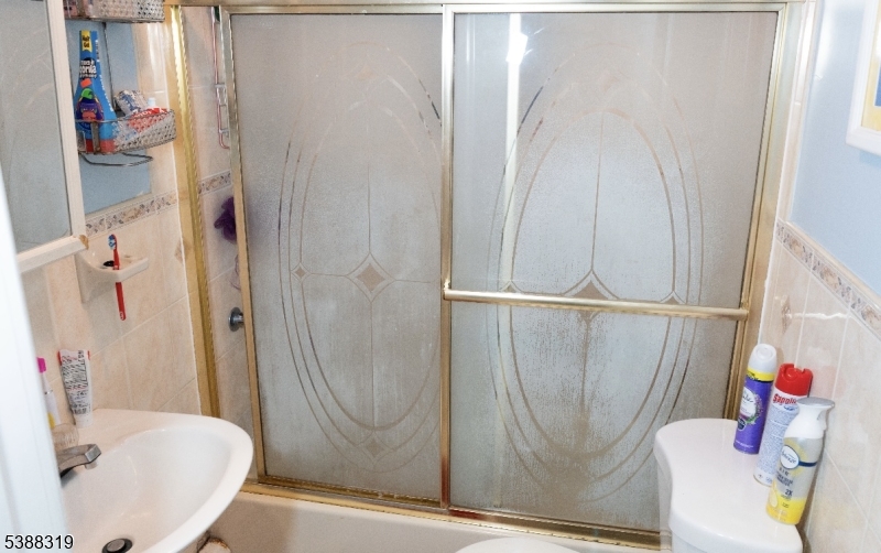 643 Elizabeth Avenue Elizabeth Port, NJ 07206 - Photo 23 of 36 a bathroom with a sink and a shower curtain