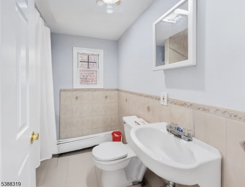643 Elizabeth Avenue Elizabeth Port, NJ 07206 - Photo 27 of 36 a bathroom with a sink toilet and a mirror