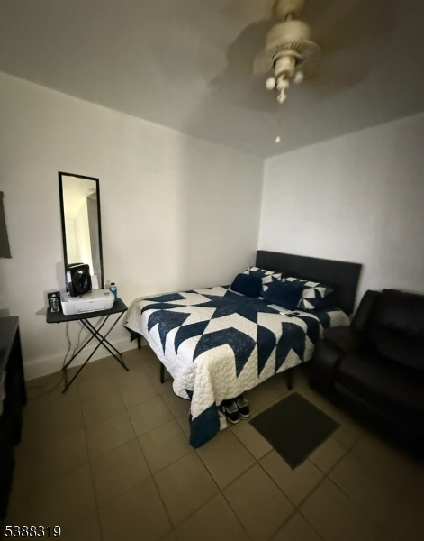 643 Elizabeth Avenue Elizabeth Port, NJ 07206 - Photo 35 of 36 a bedroom with a bed and a chandelier