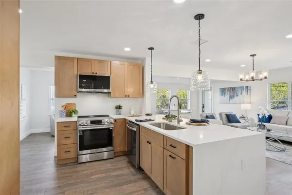 a kitchen with a sink stove and wooden floor