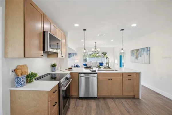 a kitchen with a sink a counter space appliances and cabinets