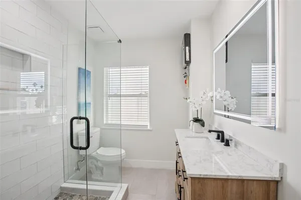 a bathroom with a granite countertop sink a toilet and shower