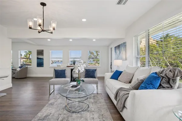 a living room with furniture chandelier and a large window