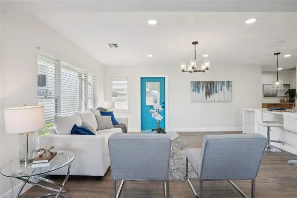 a living room with furniture a rug and a chandelier