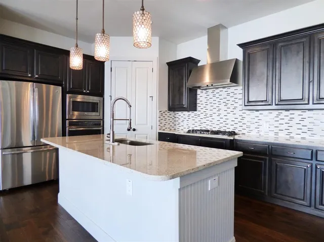 a kitchen with stainless steel appliances granite countertop a sink refrigerator and microwave