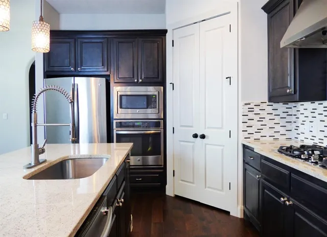 a kitchen with granite countertop a refrigerator and a sink