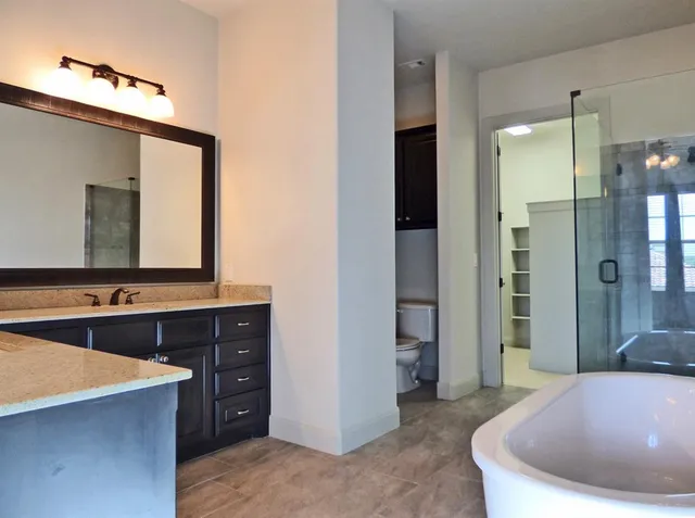 a spacious bathroom with a bathtub and a double vanity sink