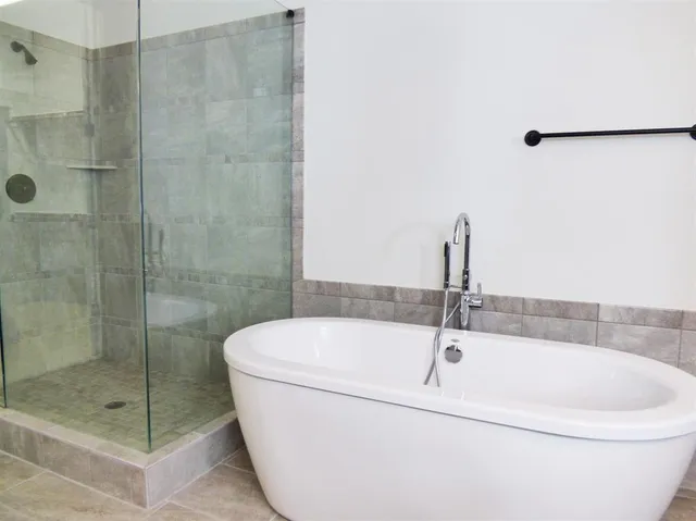 a white bath tub sitting next to a shower
