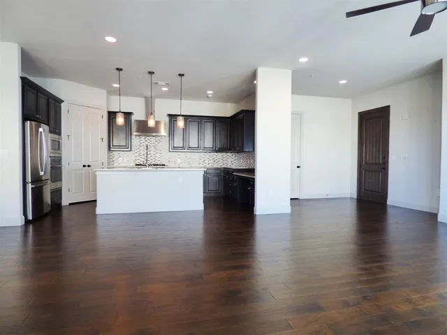 a view of kitchen view wooden floor stainless steel appliances and cabinets