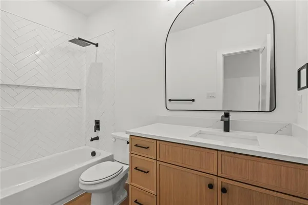 a bathroom with a sink toilet vanity mirror and bathtub