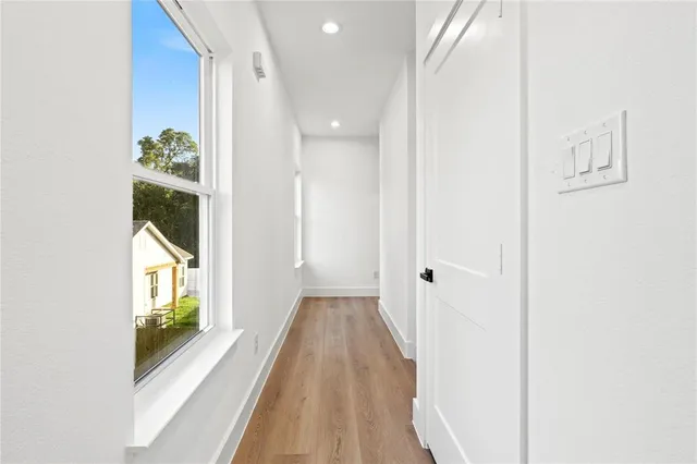 a view of a hallway with wooden floor and entryway