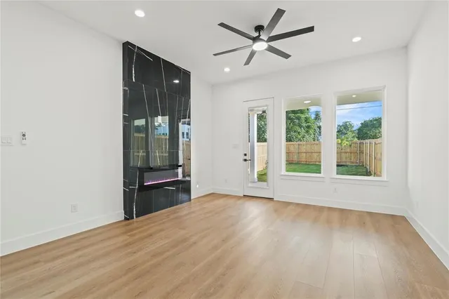 a view of an empty room with a window and wooden floor