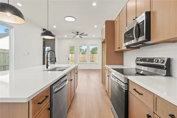 a kitchen with stainless steel appliances granite countertop a sink and a stove