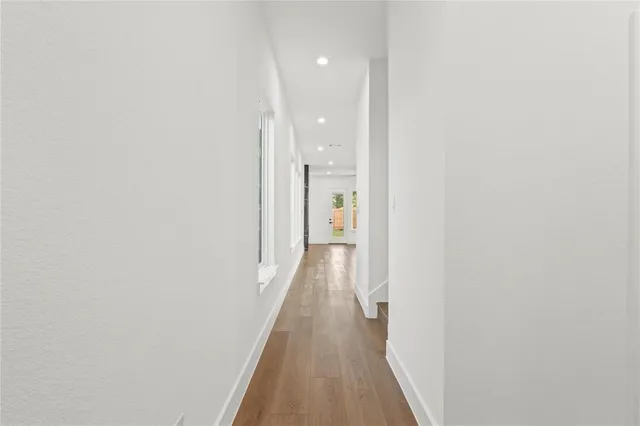 a view of a hallway with wooden floor