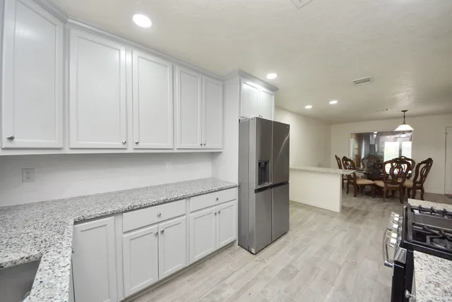 a kitchen with stainless steel appliances granite countertop a refrigerator sink and cabinets