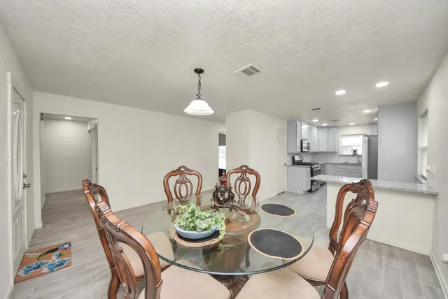 a dining room with furniture and a wooden floor