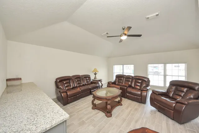 a living room with furniture a ceiling fan and a rug