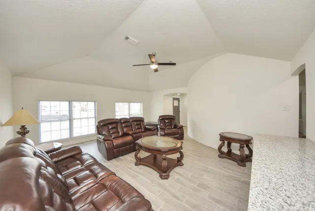a living room with furniture and a wooden floor