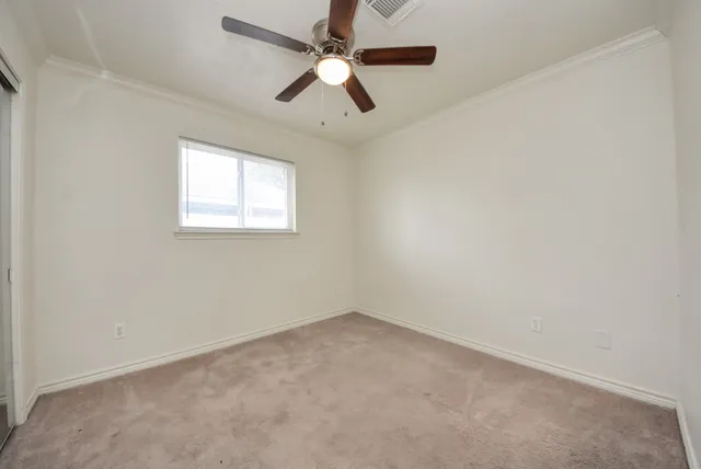 an empty room with a window and a fan