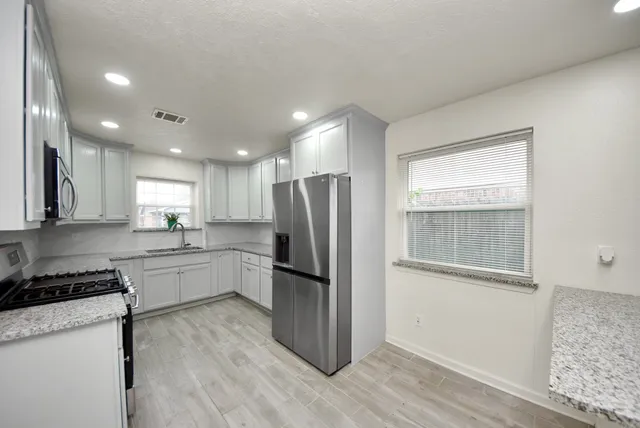 a kitchen with a refrigerator and a stove top oven