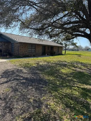 a backyard of a house with a large tree