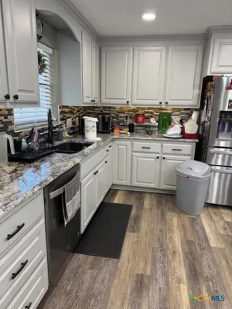 a kitchen with granite countertop appliances cabinets and a sink