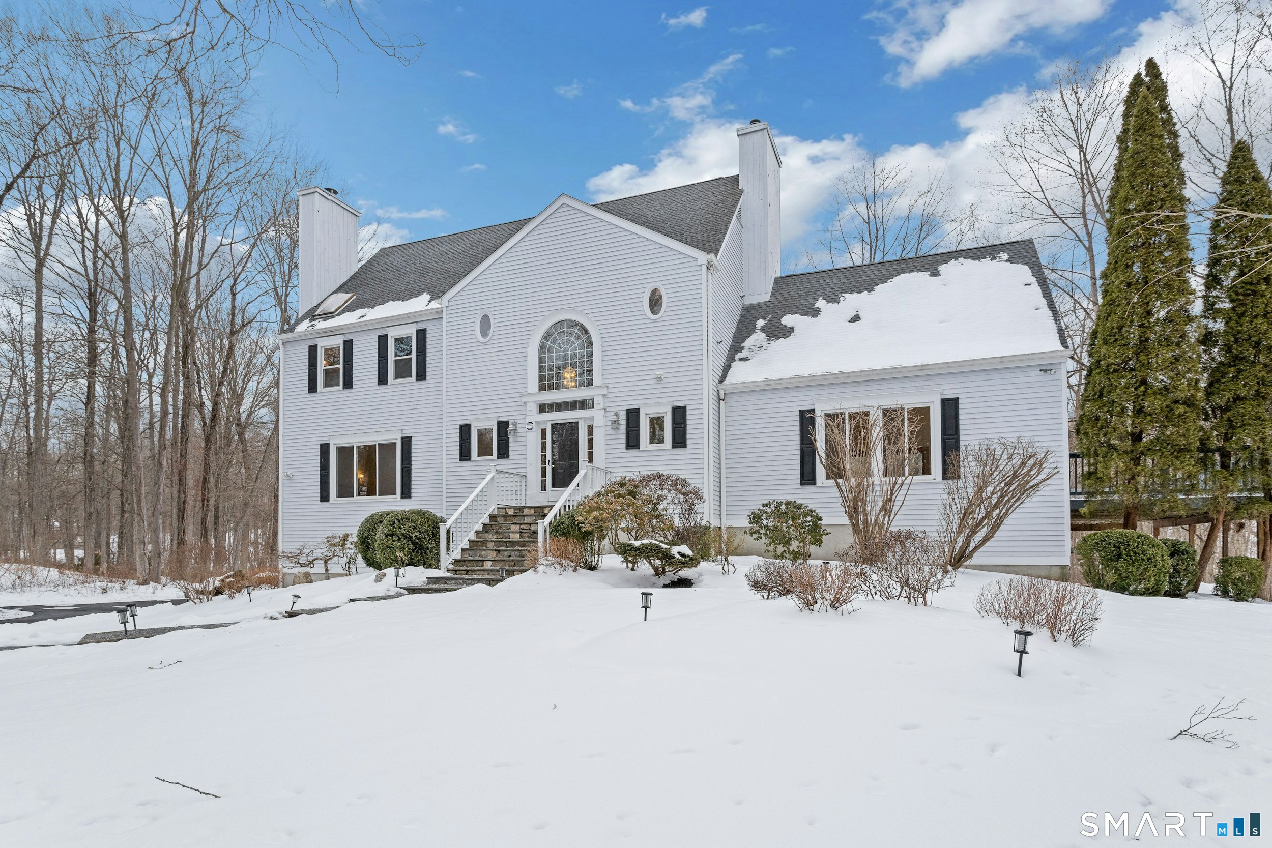 6 Morganti Court Ridgefield, CT 06877 - Photo 3 of 36 a front view of a house with a yard covered in snow