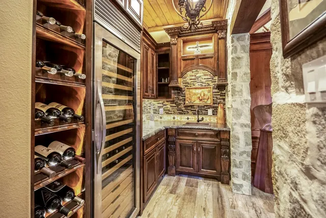 a living room with couches a flat tv screen and a dining table with wooden floor