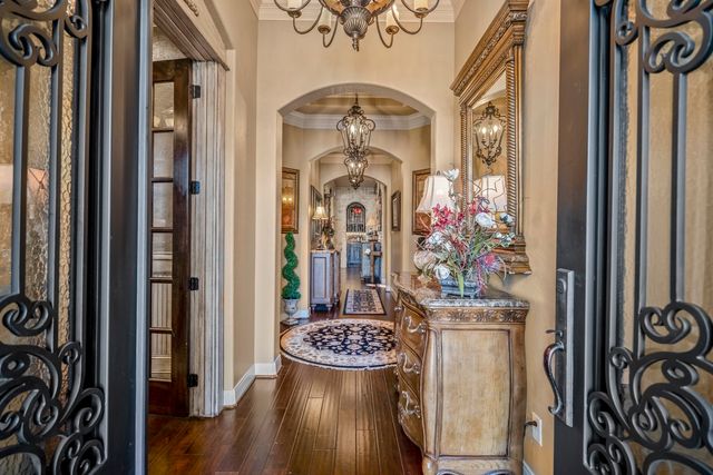 a view of a hallway with wooden floor and a chandelier