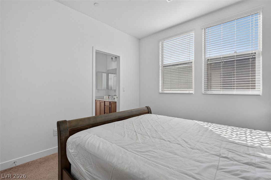 1100 East Sunset Road Henderson, NV 89011 - Photo 37 of 58 A well-lit bedroom with soft carpeting offers direct access to a private full bathroom.