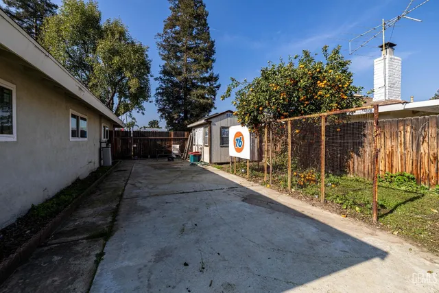 a view of a house with backyard and a tree
