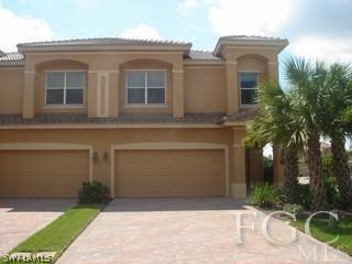 a front view of a house with garage and plants