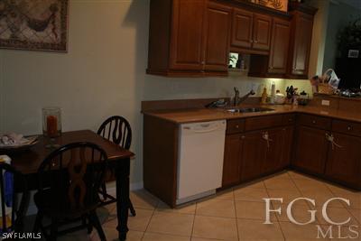 20244 Larino Loop Estero, FL 33928 - Photo 4 of 10 a kitchen with granite countertop a sink a stove and wooden cabinets