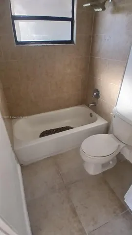 a bathroom with a granite countertop toilet and a shower