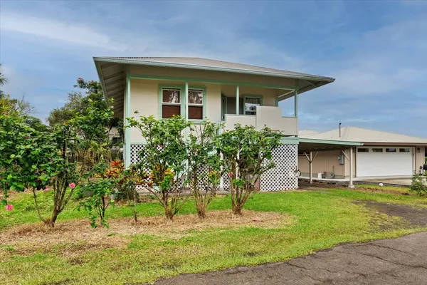 a front view of house with a garden