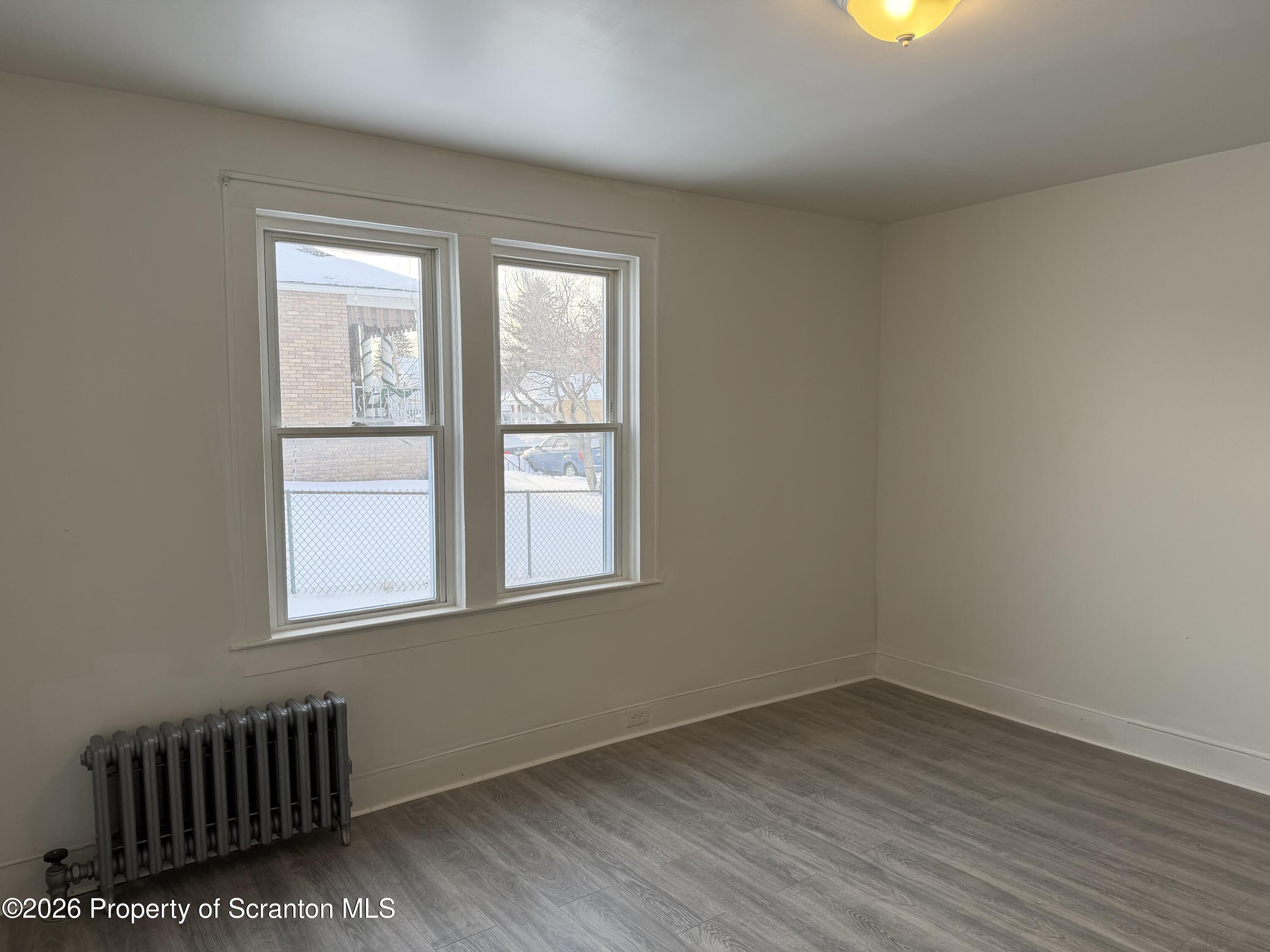 101 Clarkson Street, Unit 1 Jessup, PA 18434 - Photo 13 of 13 an empty room with wooden floor and windows