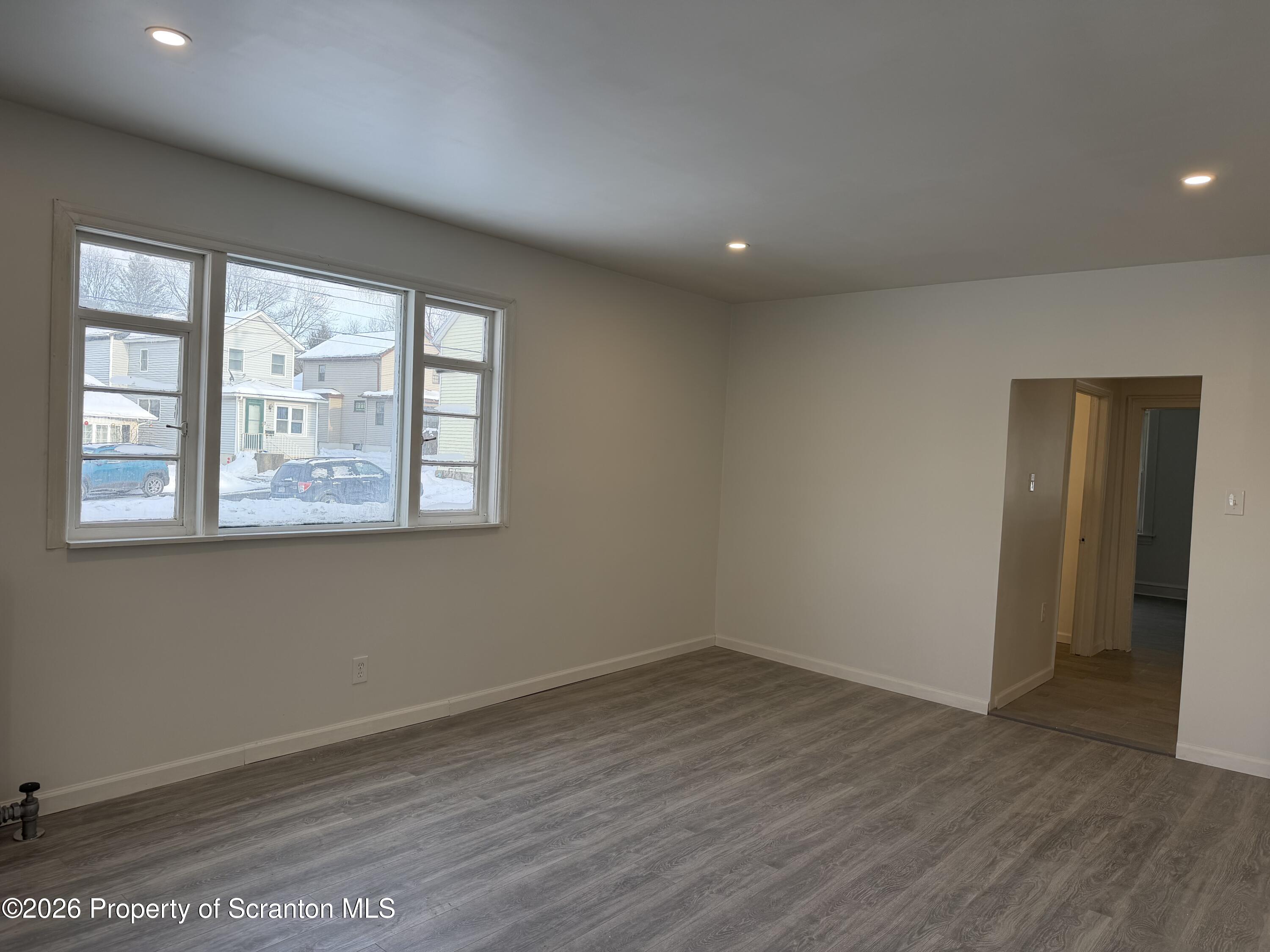101 Clarkson Street, Unit 1 Jessup, PA 18434 - Photo 4 of 13 an empty room with wooden floor and windows