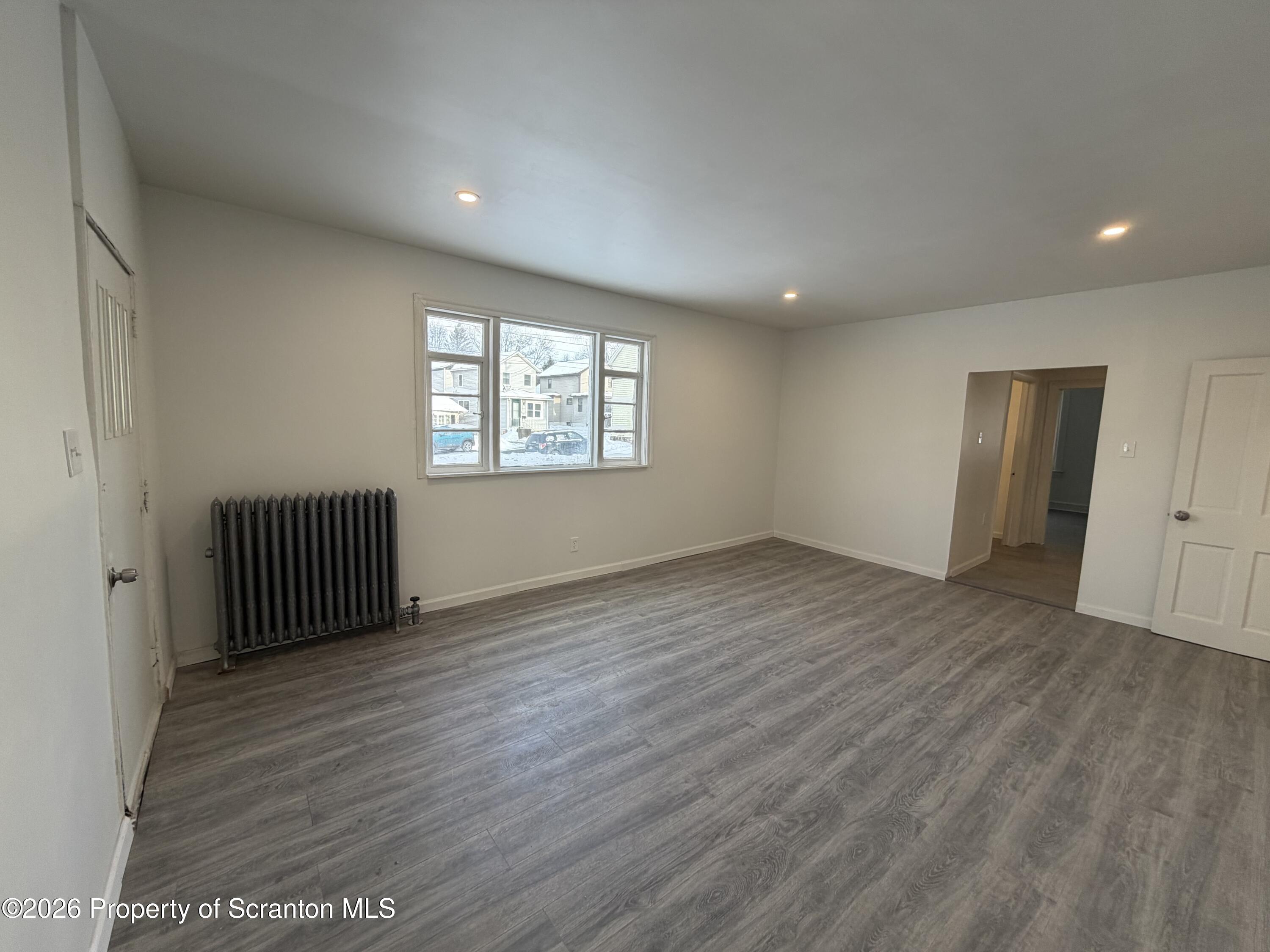101 Clarkson Street, Unit 1 Jessup, PA 18434 - Photo 5 of 13 an empty room with wooden floor and windows