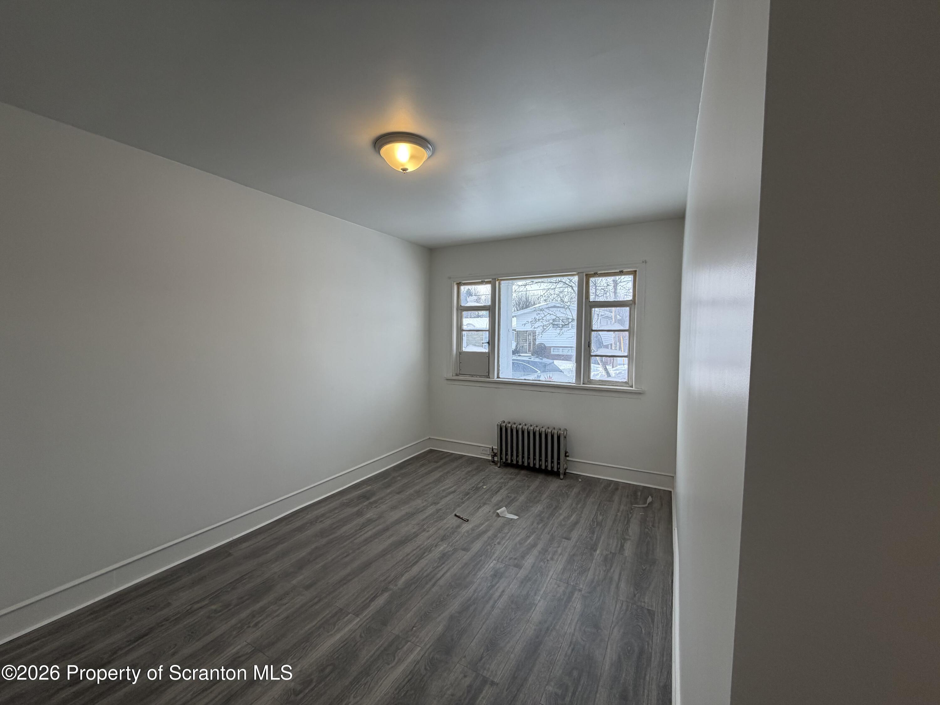 101 Clarkson Street, Unit 1 Jessup, PA 18434 - Photo 7 of 13 an empty room with wooden floor and windows